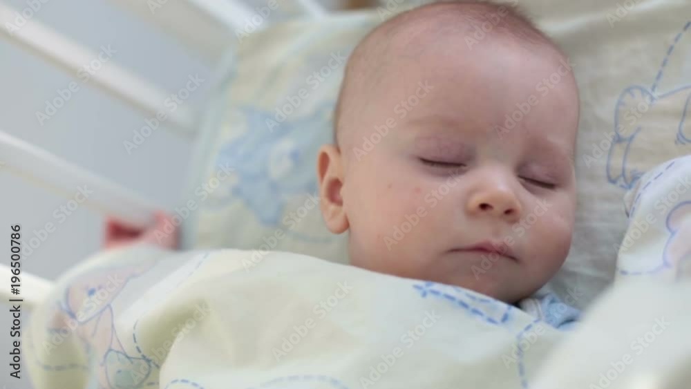 Close up of a little baby boy sleeping, baby lying in baby cot