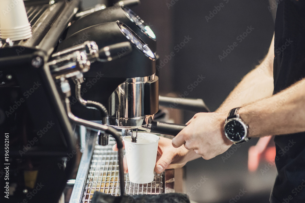 Barista preparing coffee in a cafe. Professional coffee making, service and catering concept