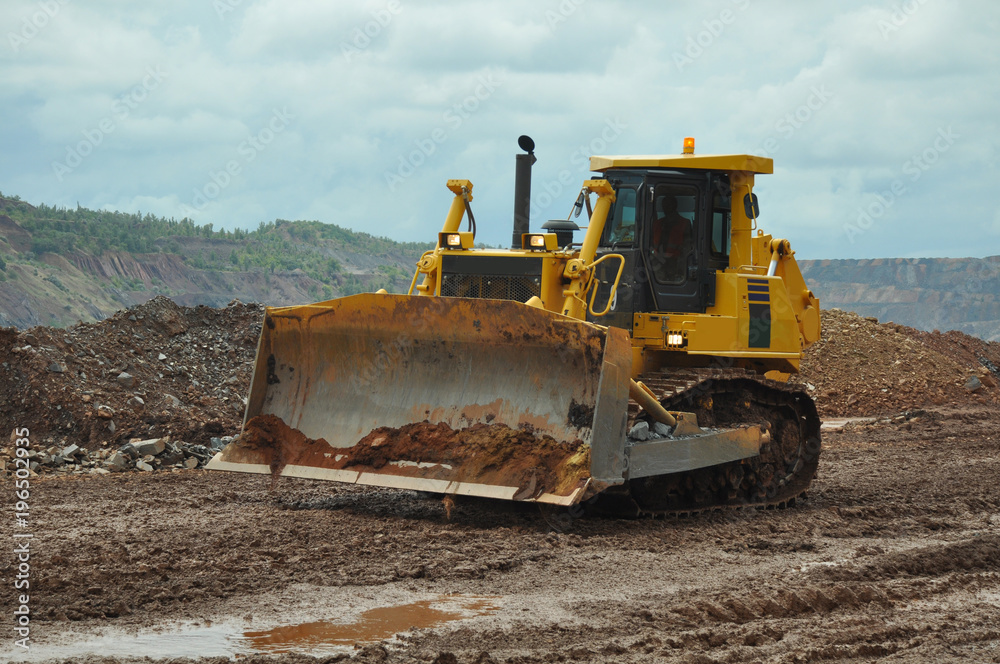Bulldozer operation in the ore quarry. Clearing the embankment with a bucket. Bulldozer operation in the ore quarry. Clearing the embankment with a bucket.