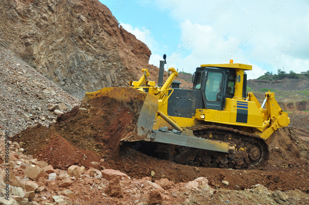 Bulldozer operation in the ore quarry. Clearing the embankment with a bucket.