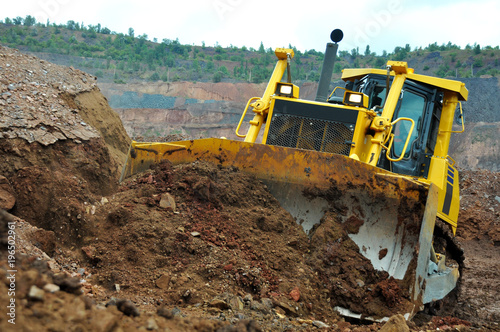 Bulldozer operation in the ore quarry. Clearing the embankment with a bucket.