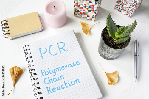 PCR Polymerase Chain Reaction written in notebook on white table