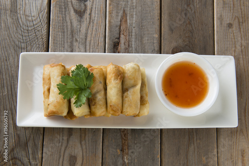 Lumpia Spring Rolls on Wooden Table in Restaurant photo