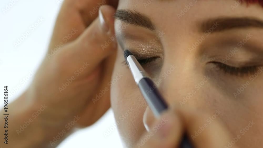 Close-up of professional make-up artist doing everyday makeup, puts powder on womans cheeks with brush Close-up of professional make-up artist doing everyday makeup, puts powder on womans cheeks with brush