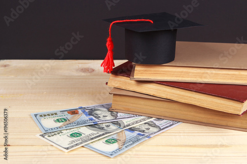 Graduation cap with book in front of black board photo