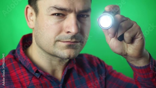 man works flashlight green screen background