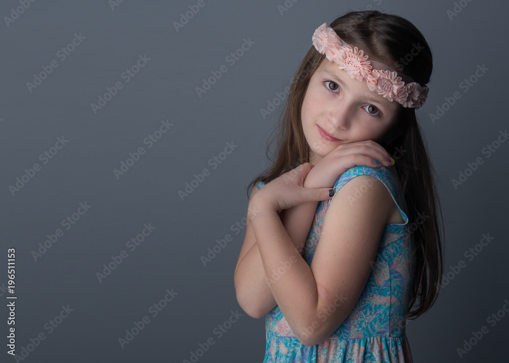 Studio shot of young girl with long brown hair and brown eyes