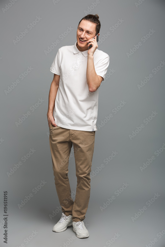 Cheerful young man talking by cellphone. Cheerful young man talking by cellphone.