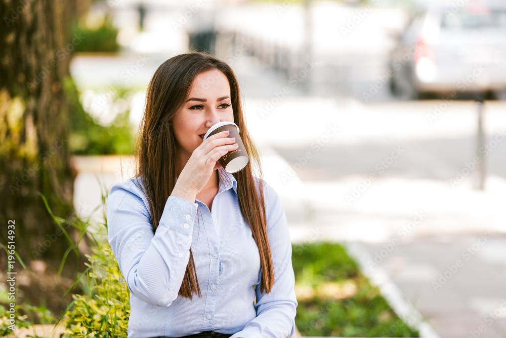 Beautiful businesswoman drinks coffee to go