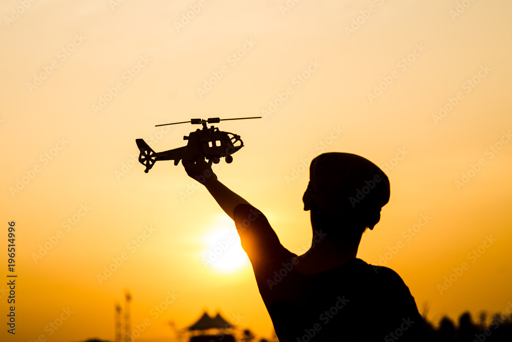 Silhouette boy playing helicopter model with sun set. Silhouette boy playing helicopter model with sun set.