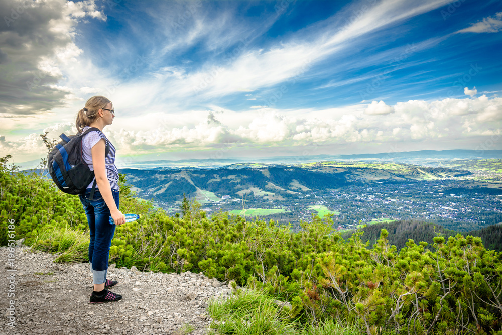 Naklejka premium Hiking with backpack, hiker woman on top of the mountain, traveling people in mountains and success concept