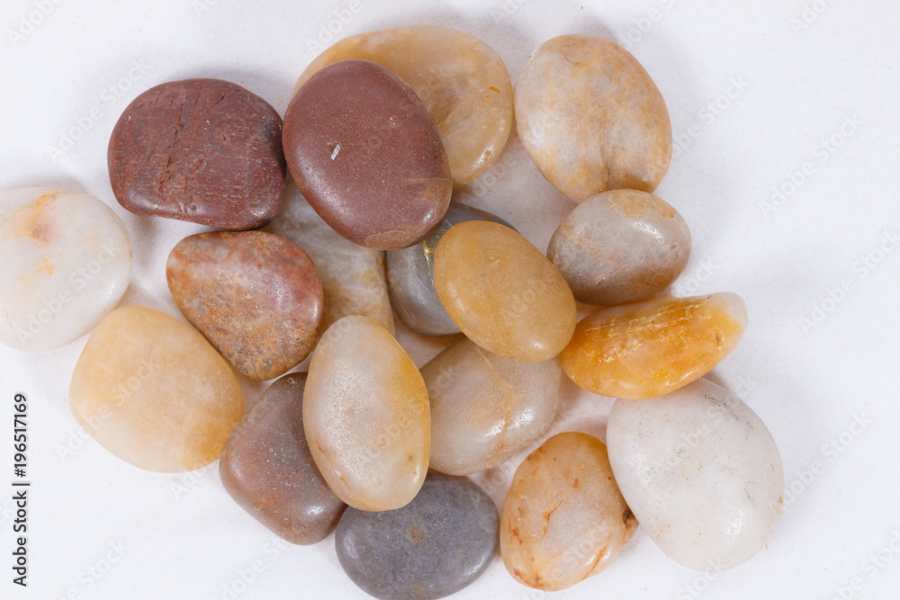 pebbles. clean white brown black pebbles isolated. the pebbles are on white or brown sand. small and large are visible pebbles. clean white brown black pebbles isolated. the pebbles are on white or brown sand. small and large are visible