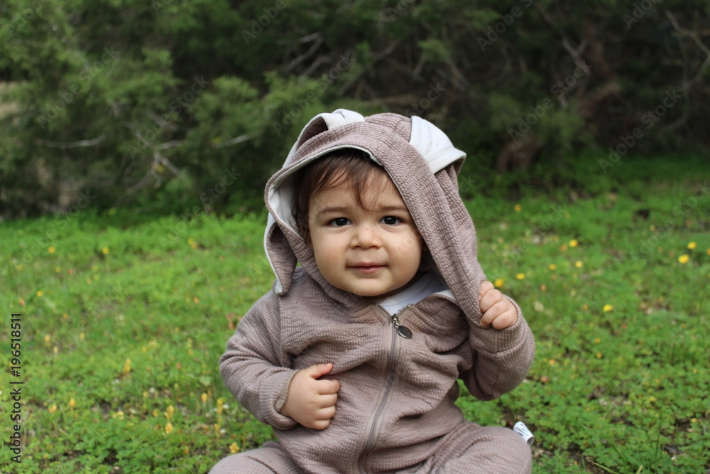 one year baby boy playing on the grass in rabbit suit one year baby boy playing on the grass in rabbit suit