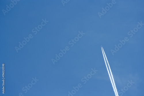 plane streak in the sky. Flying plane on the blue sky leaving behind white smoke