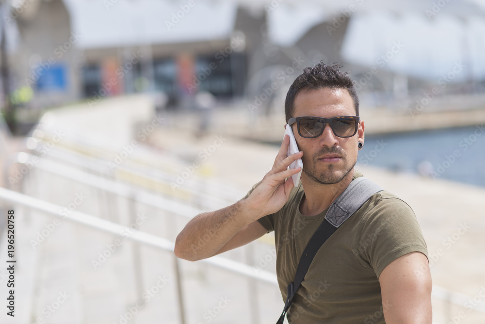 Urban man using a phone wearing sunglasses Urban man using a phone wearing sunglasses
