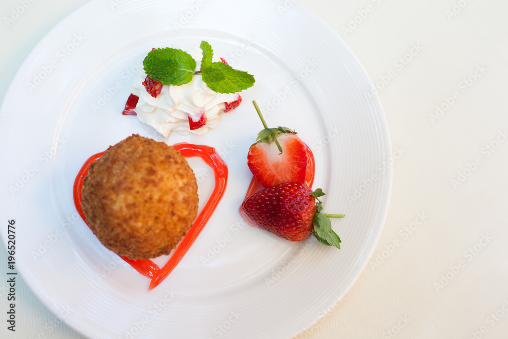 Fried ice cream with whipped cream and strawberry on plate. Fried ice cream with whipped cream and strawberry on plate.