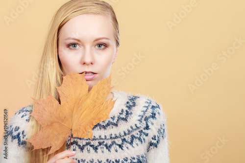 Woman holding orange autumn leaf