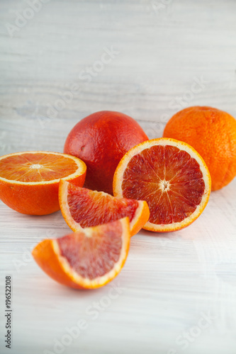 fresh ripe blood oranges, slices, rustic food photography on white wood plate kitchen table can be used as background