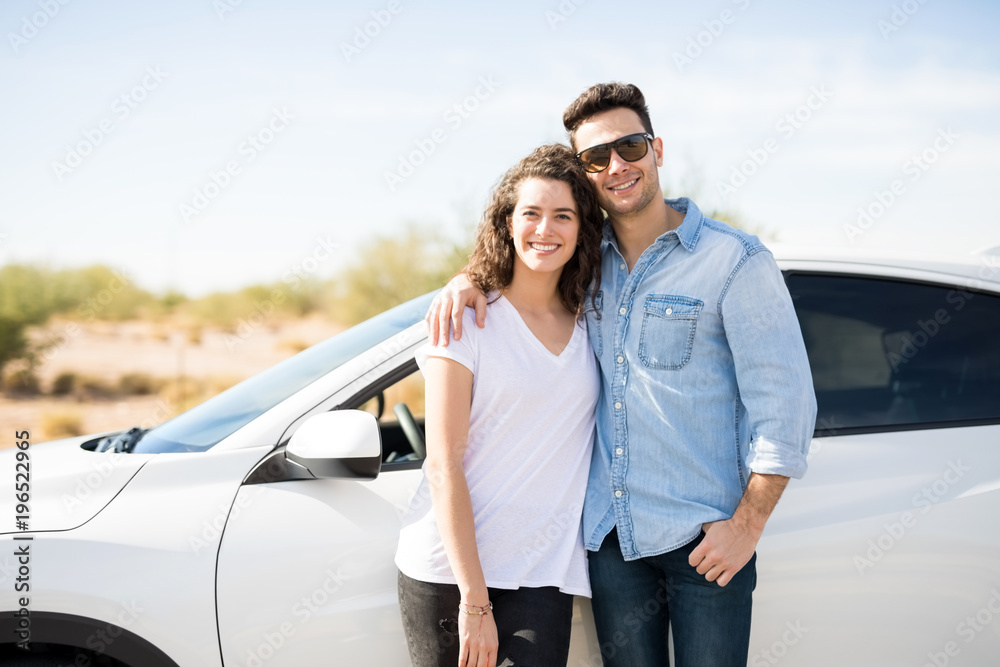 Couple on road trip standing by the car Couple on road trip standing by the car