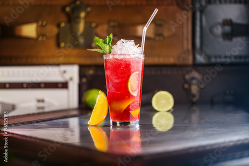 Φωτογραφία Glass of strawberry red cocktail with orange and lime.
