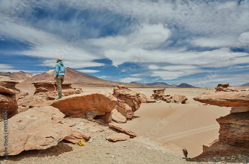 Woman standing on rock, looking at view, Villa Alota, Potosi, Bolivia, South America photo