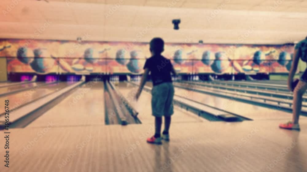Boy Playing Bowling, Retro Style. Young boy in a bowling alley throws a