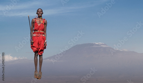 Masai man with traditional dress jumping in front of Mount Kilimanjaro, Amboseli, Rift Valley, Kenya photo