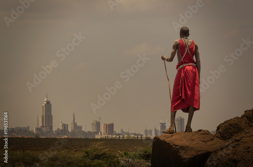 Masai man with traditional dress watching Nairobi's skyline, Nairobi, Nairobi Area, Kenya photo