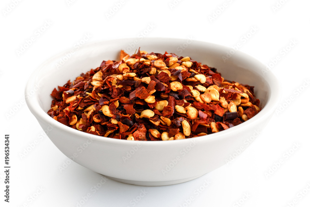Coarsely ground chilli peppers in white ceramic bowl isolated on white. Coarsely ground chilli peppers in white ceramic bowl isolated on white.