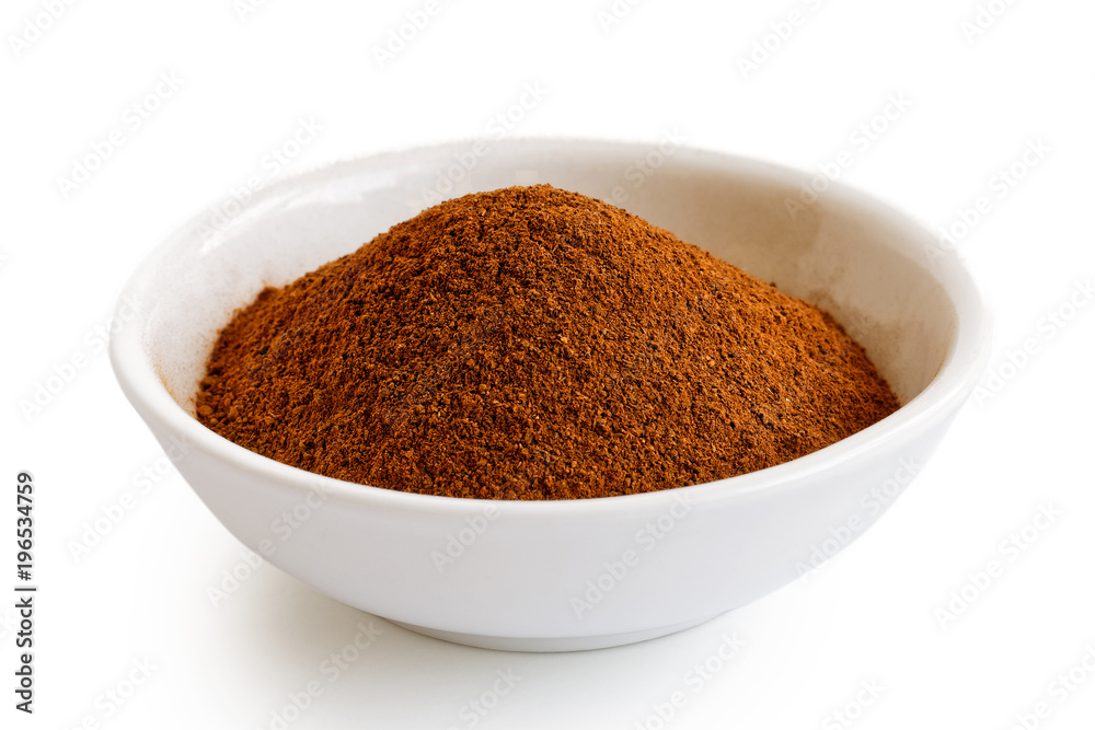 Finely ground cinnamon in white ceramic bowl isolated on white. Finely ground cinnamon in white ceramic bowl isolated on white.