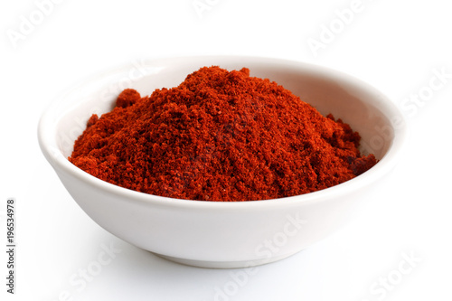 Paprika in white ceramic bowl isolated on white.