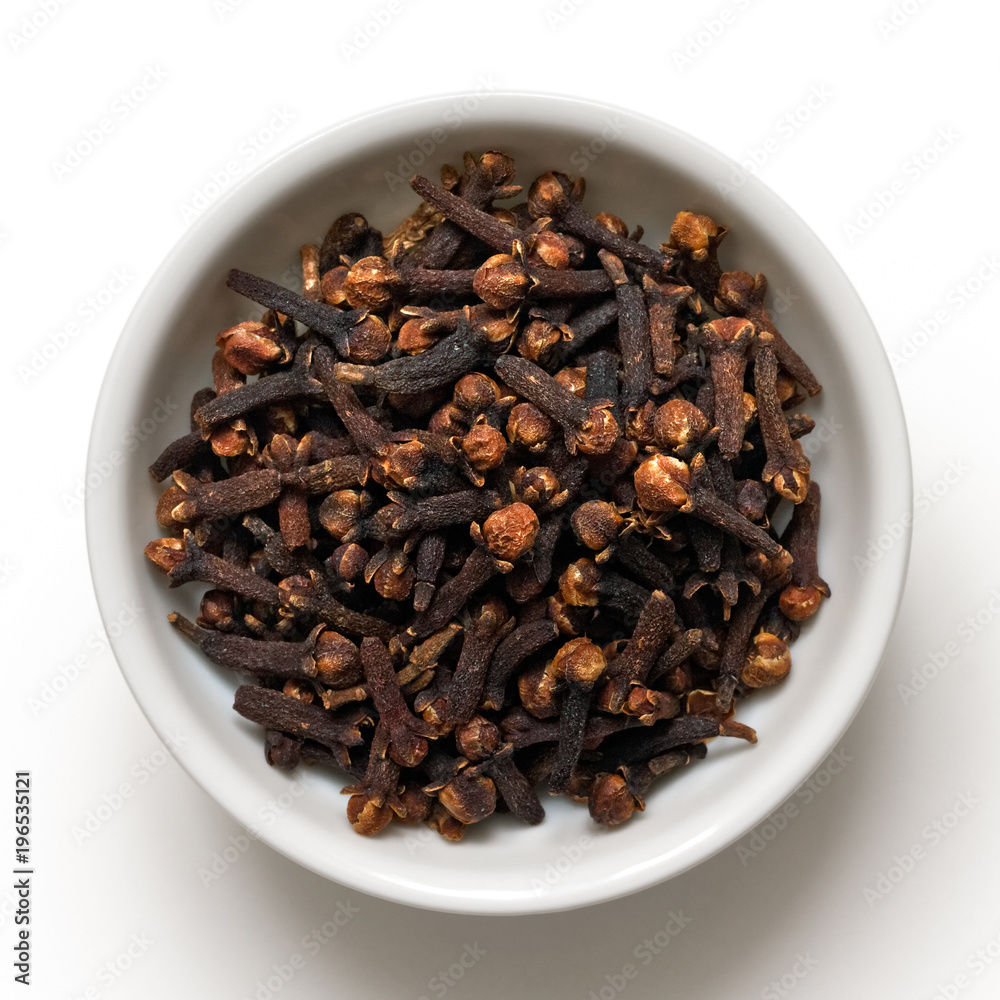 Whole cloves in white ceramic bowl isolated on white from above. Whole cloves in white ceramic bowl isolated on white from above.