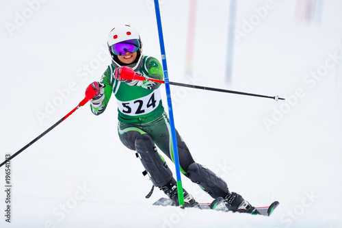 Skier at a gate on the slalom race course photo