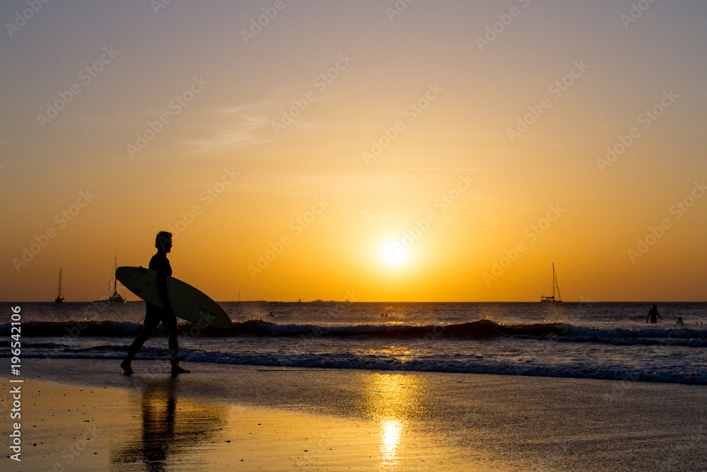 Beach sunset with silhouetted surfer
