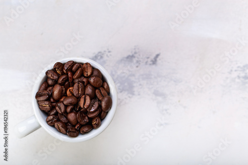 Coffee beans in white coffee cup brown white background