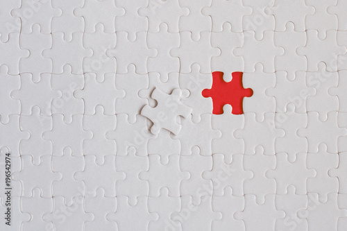 White details of jigsaw puzzle on red background photo