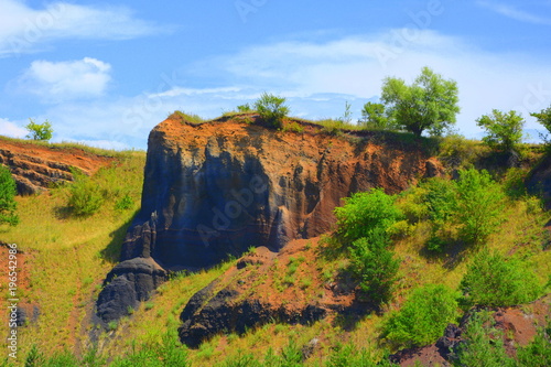 Abandoned career of red scorea rocks. Racos is a village in Brasov county, Transylvania, Romania near one active and three abandoned stone career photo