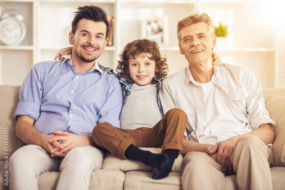 Generation portrait. Grandfather, father and son sitting on sofa Generation portrait. Grandfather, father and son sitting on sofa