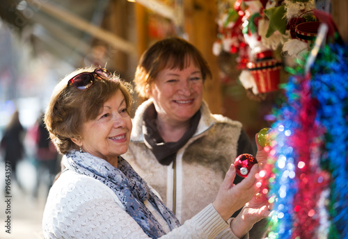 Happy mature women purchasing Christmas decorations