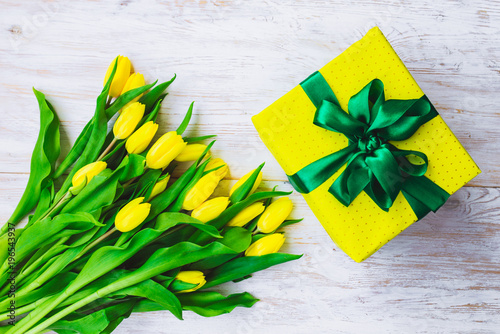 gift box with bouquet of yellow tulips. overhead view