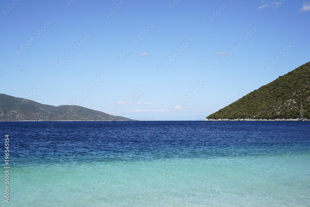 Bright blue sea and green mountains, sunny summer day at sea