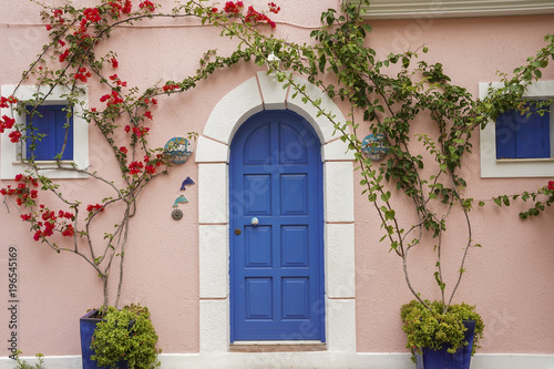 Bright blue door on the background of a pink wall