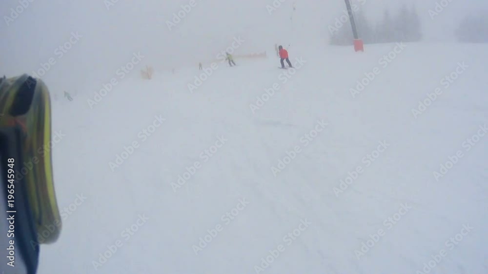 Skiers, mostly children, skiing downhill in snowy winter mountains. Ski goggles visible on the left
Skiers, mostly children, skiing downhill in snowy winter mountains. Ski goggles visible on the left