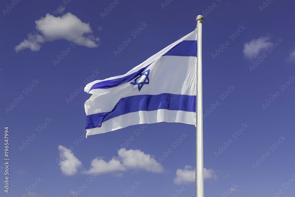 Israel flag flapping in the wind isolated against the blue sky. The flag is on a pole and flapping to the left. there are white clouds in the sky Israel flag flapping in the wind isolated against the blue sky. The flag is on a pole and flapping to the left. there are white clouds in the sky
