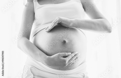 Pregnant woman isolated on background. Holding her belly