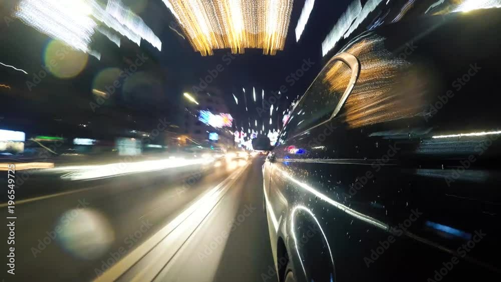 Hyperlapse from a moving car on a street at night with Christmas lights