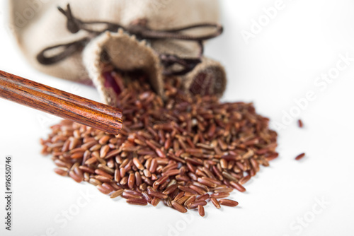 Wild red rice with sticks on white background