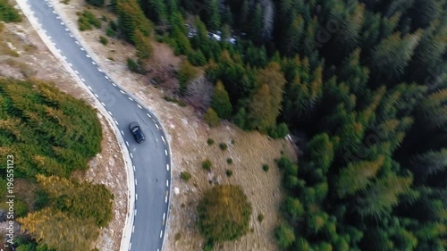 Aerial tracking shot of a car on a mountain road