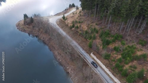 Aerial moving shot of a car driving on a mountain road photo