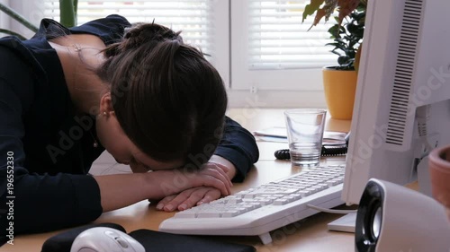 Overtime - young woman is exhausted and frustrated at the office work